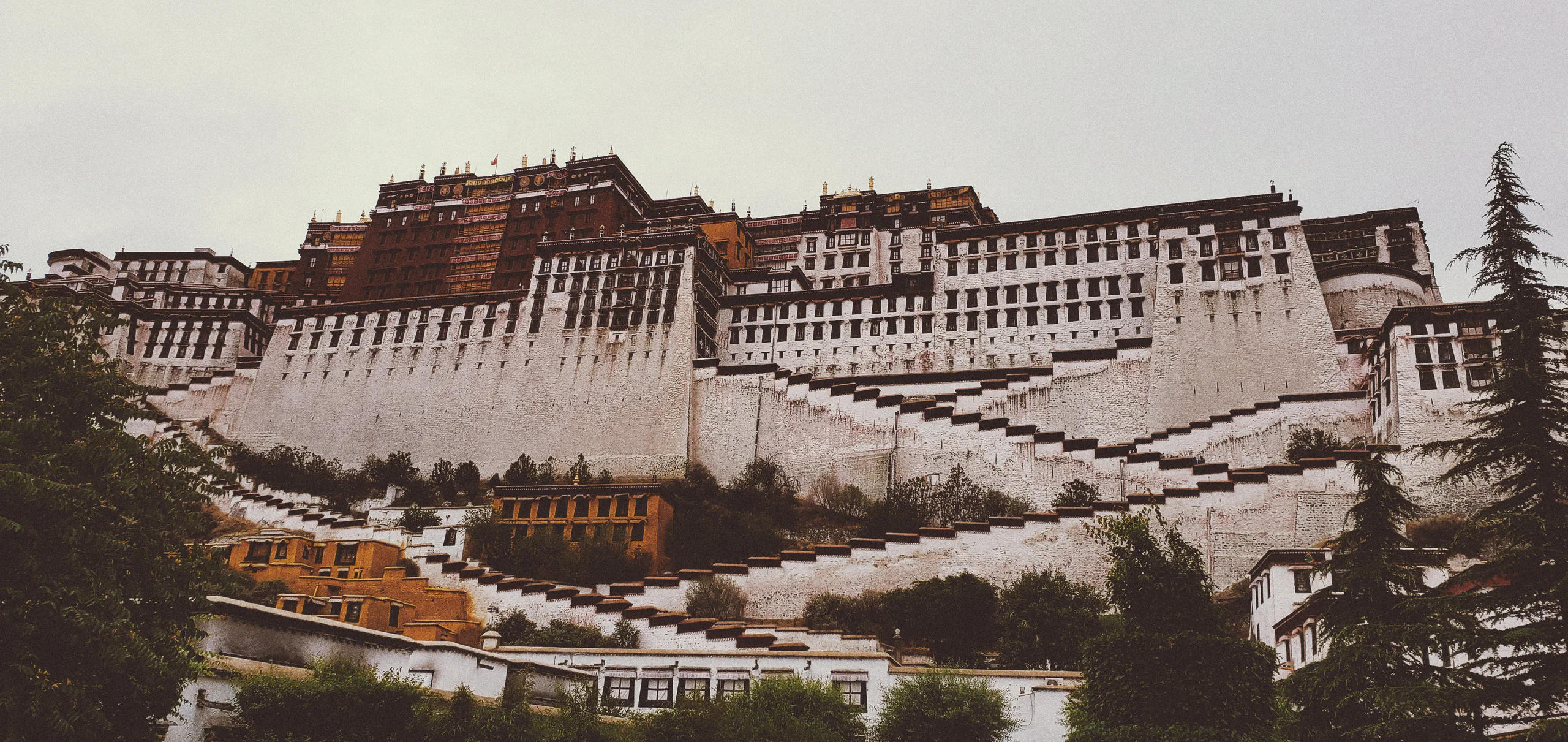 山地宫殿建筑的黑白远景，层叠屋顶沿山势展开