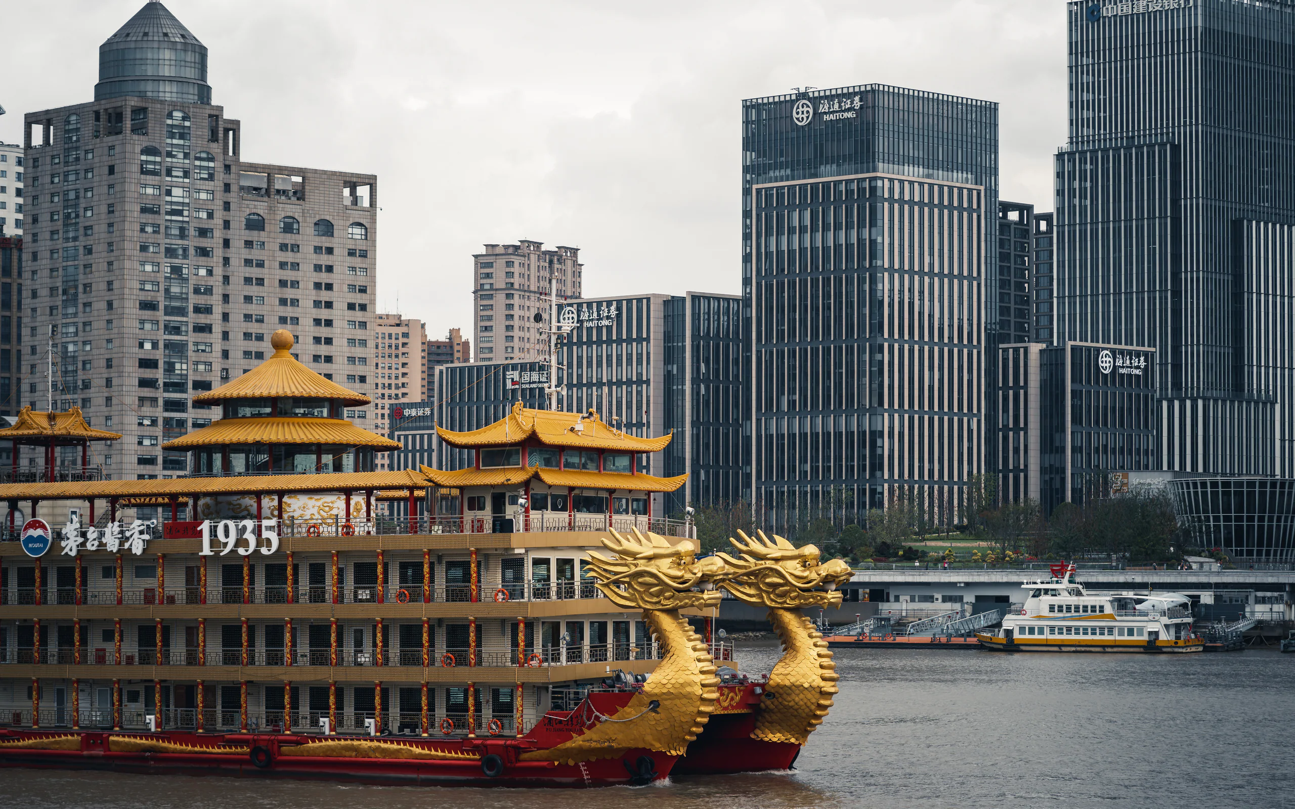 金色水上建筑或船只位于城市高楼与河岸之间
