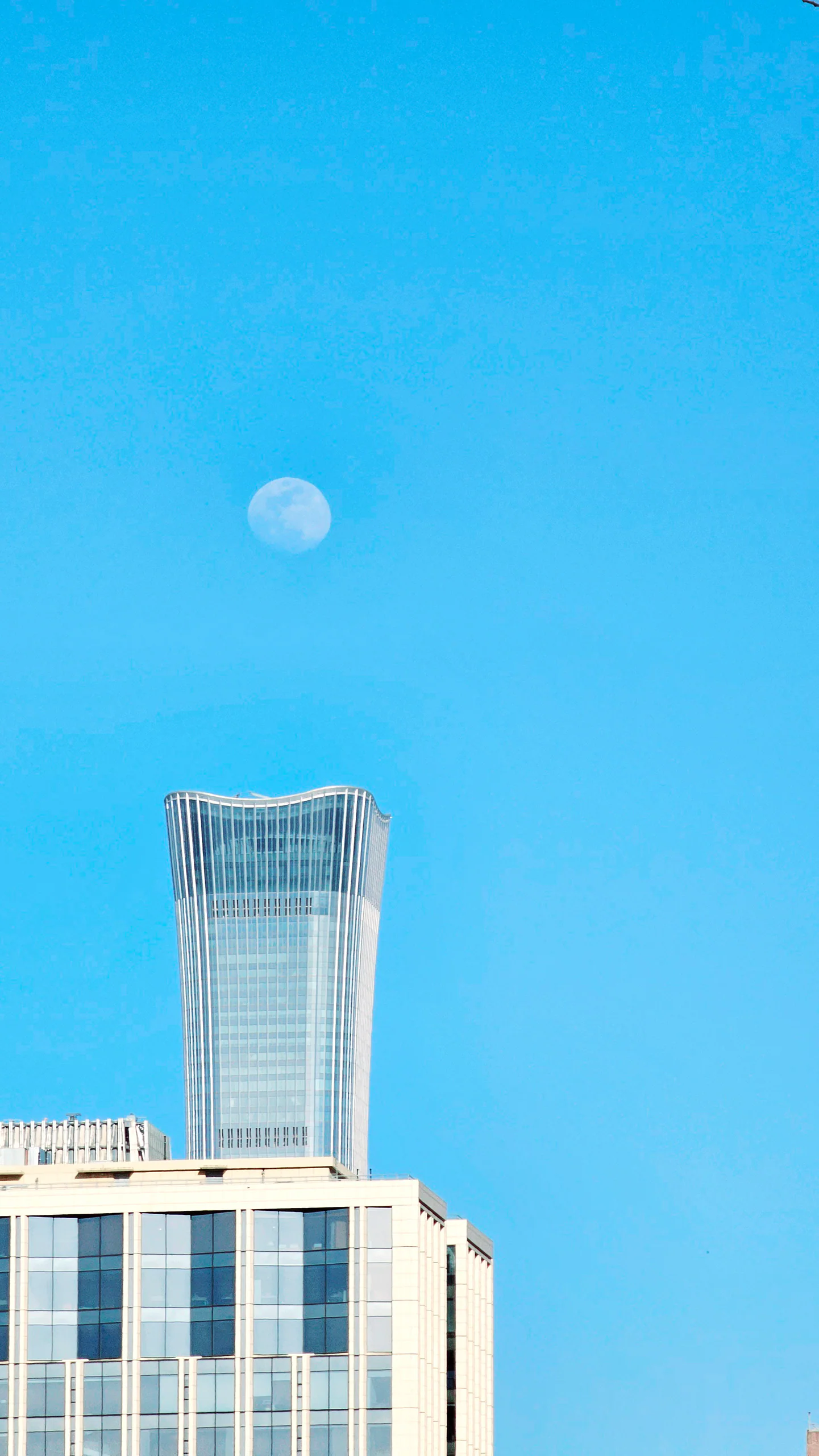 高层建筑从画面底部向明亮的蓝色天空延伸